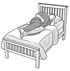 Man lying on side in bed with pillow under head and pillow between knees.